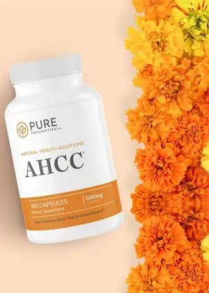 bottle of AHCC against a group of flowers.