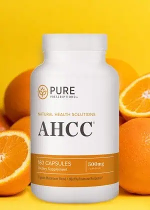 Bottle of AHCC in front of a group of oranges.
