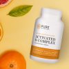 Activated B-Complex flat lay against oranges and grapefruits.