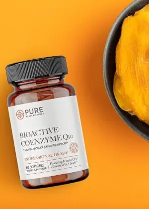 Bioactive CoEnzyme Q10 flatlay beside a bowl of mangoes