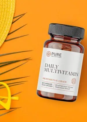 Daily Multivitamin flatlay against sunglasses and a hat.