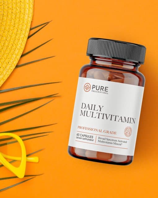 Daily Multivitamin flatlay against sunglasses and a hat.