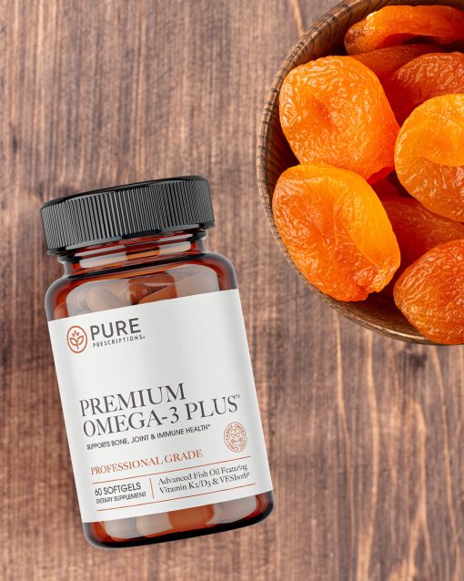 Premium Omega-3 Plus flatlay beside a bowl of apricots.