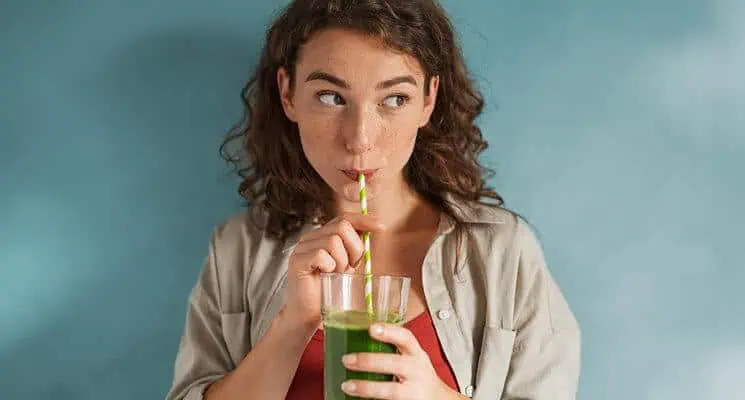 Woman Drinking NewGreens from a Glass.