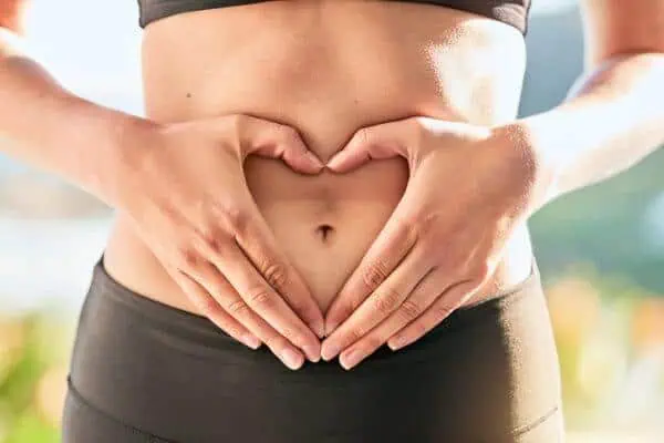 Woman making a heart over her stomach.