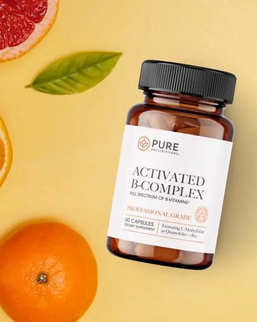 Pure Prescriptions Activated B-Complex bottle in a citrus flatlay with grapefruit, orange, and lemon leaf on a soft yellow background